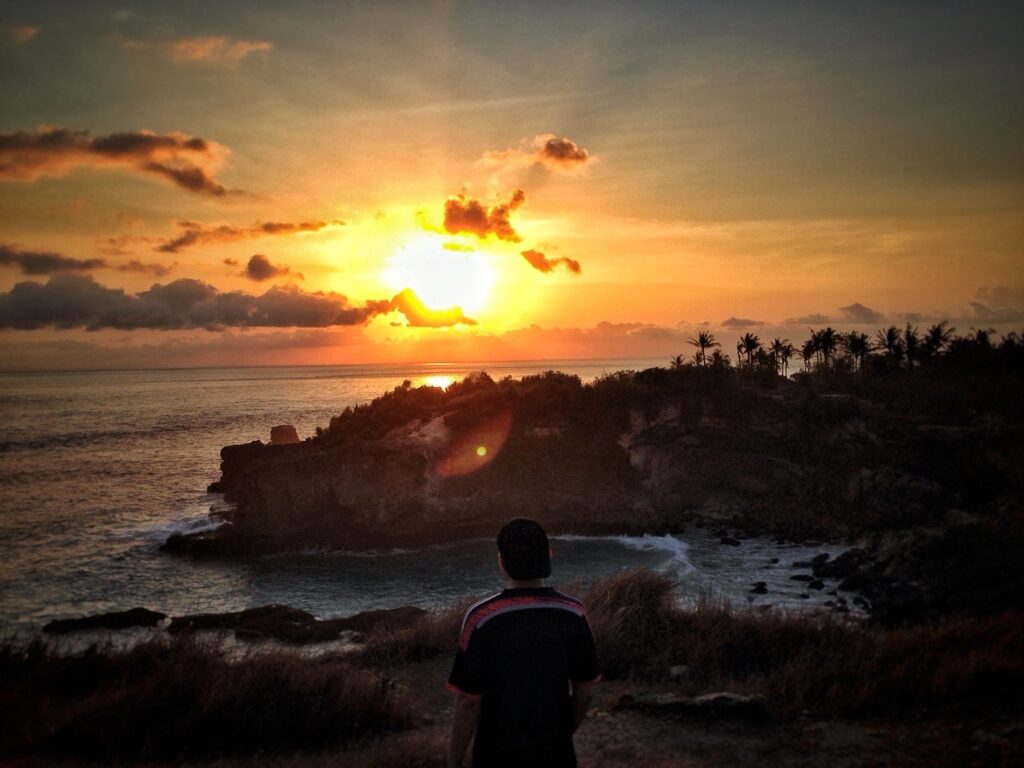 Golden hour sunset over Bali coastline with warm orange sky