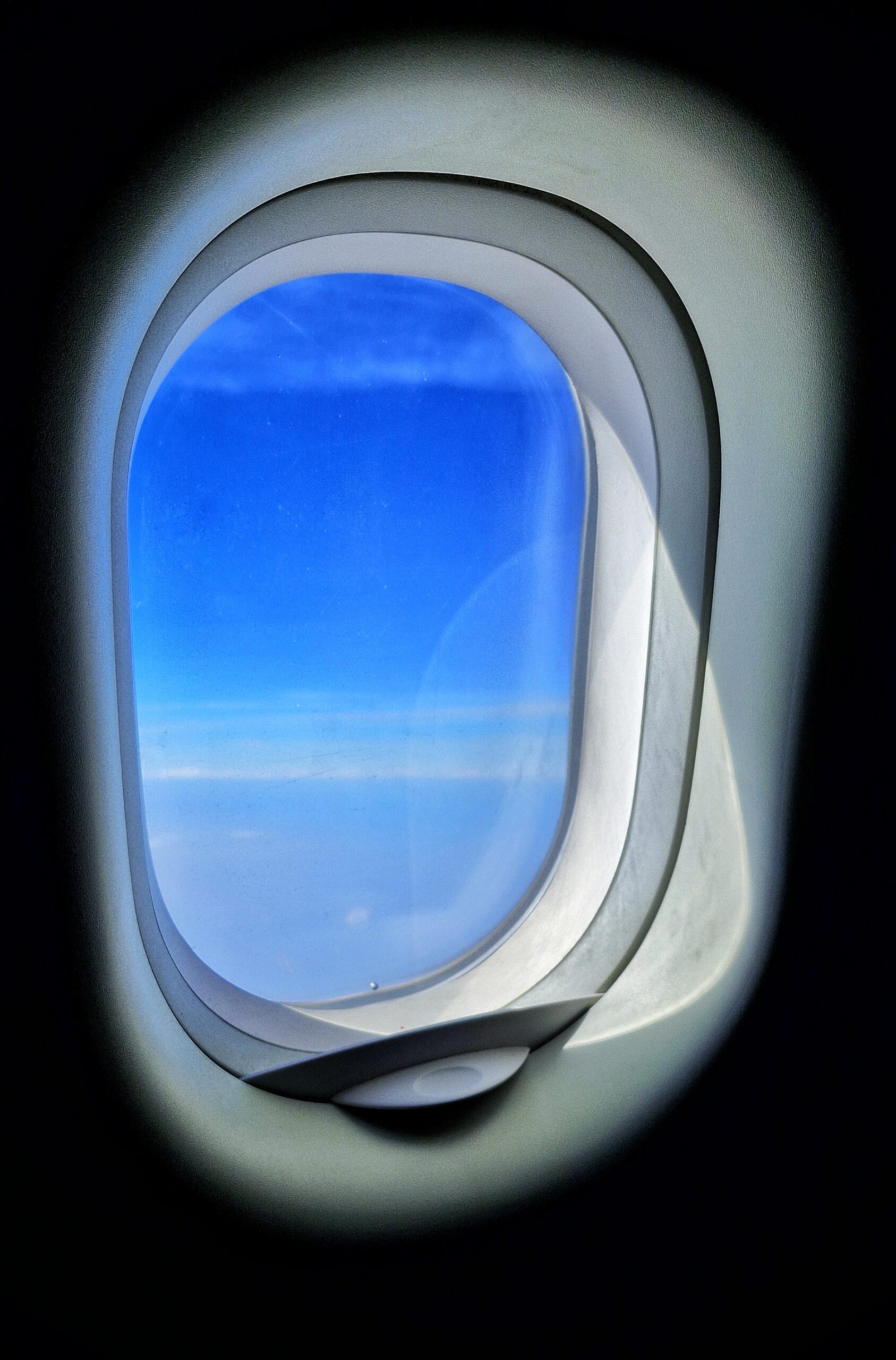 Travel photography shot from airplane window above the clouds