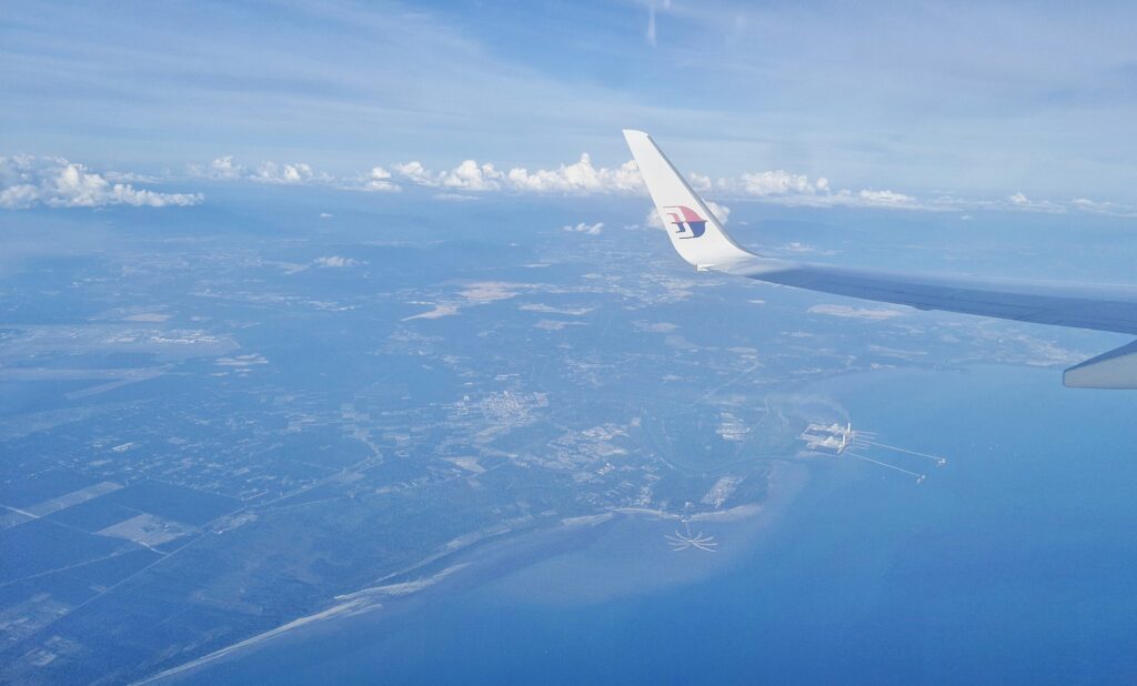 Aerial view from airplane window showing coastline and ocean