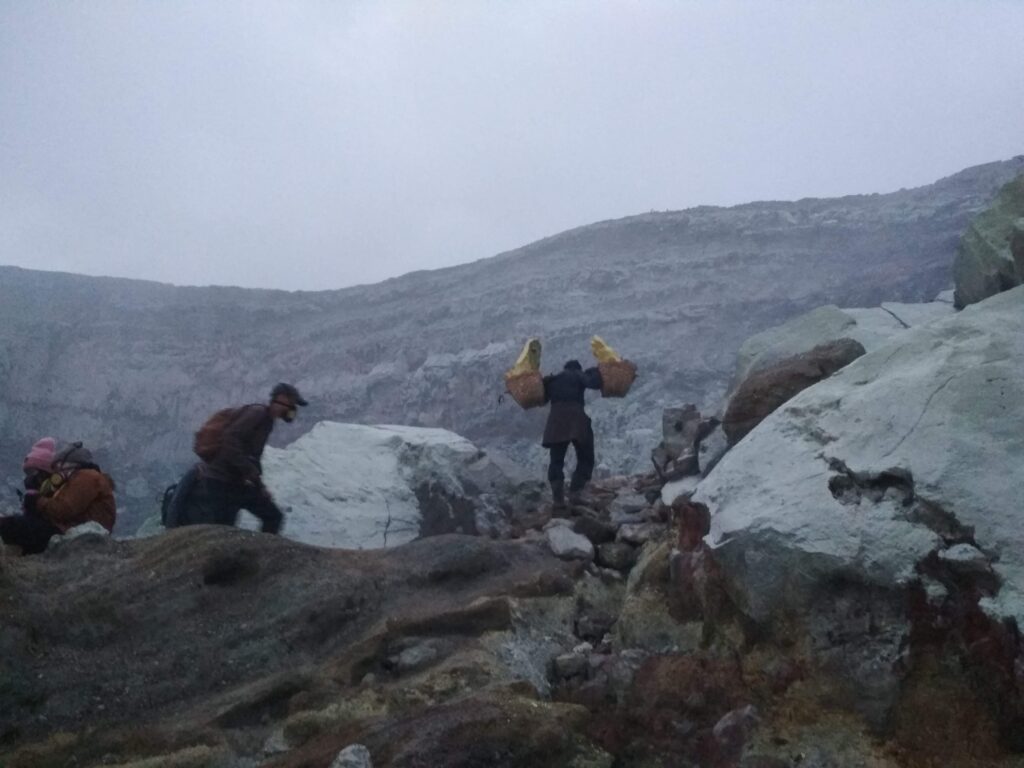 Sulfur miner carrying heavy sulfur blocks inside Ijen Crater East Java