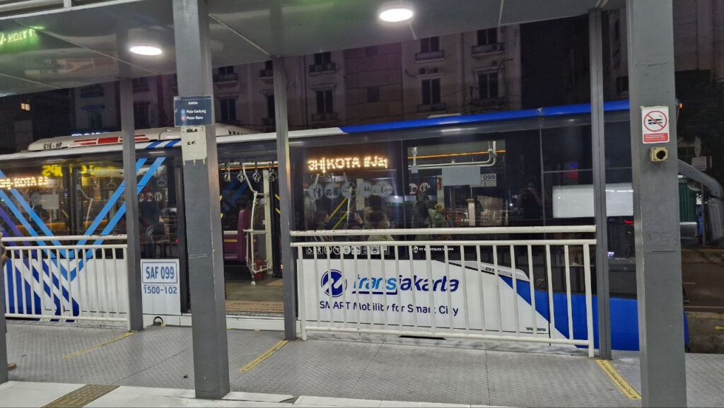 TransJakarta bus stopping at a station in central Jakarta