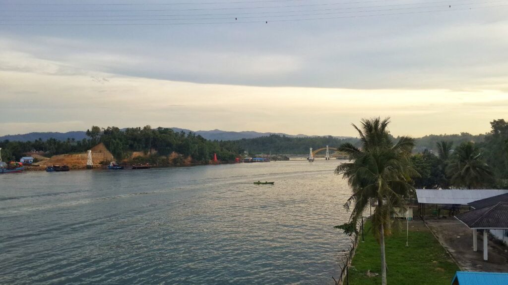 Golden hour silhouette of Teluk Kendari Bridge from the waterfront