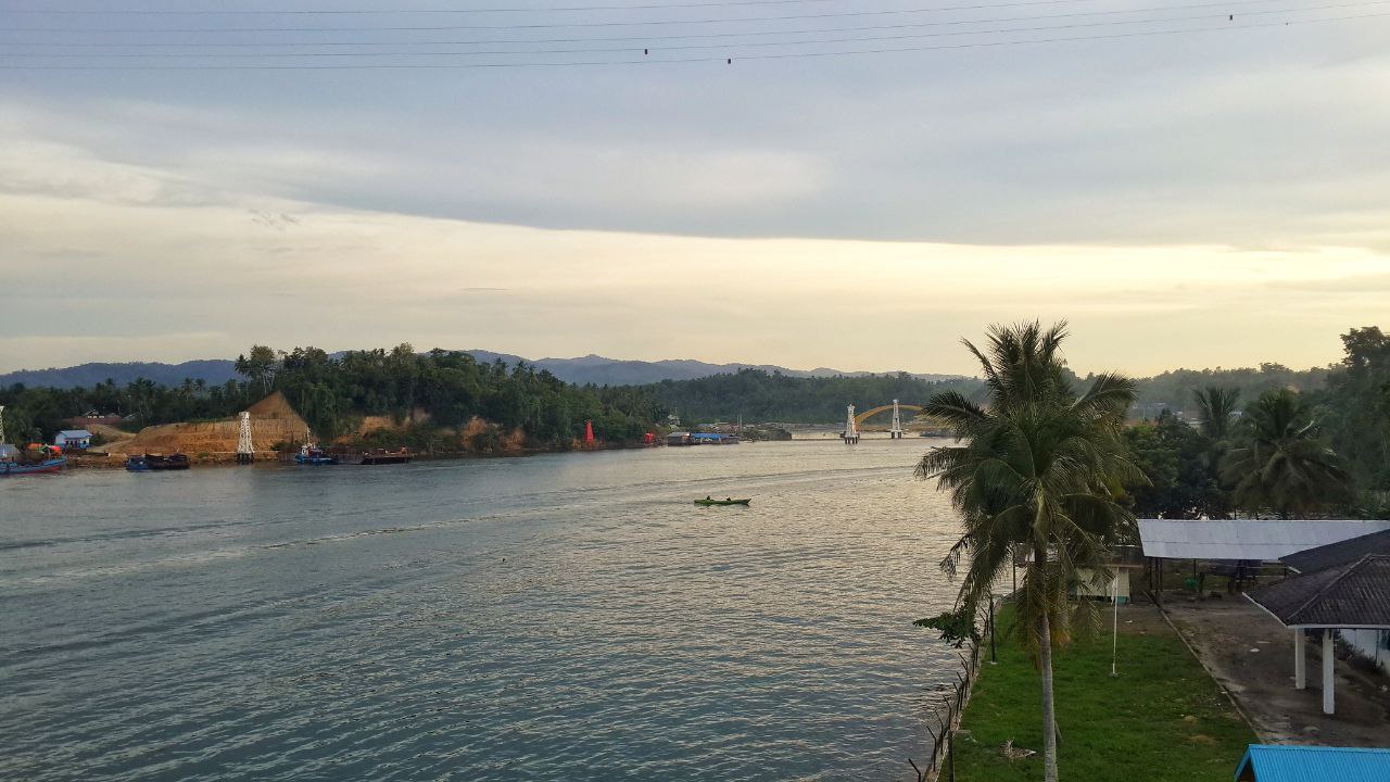 Golden hour silhouette of Teluk Kendari Bridge from the waterfront