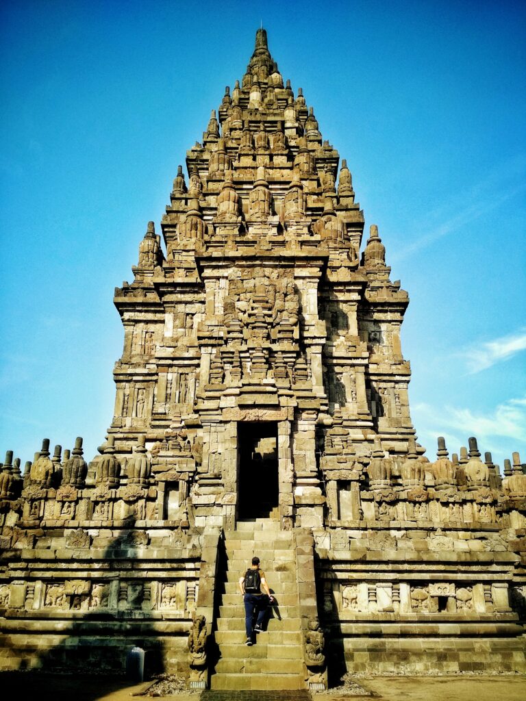 Tourists walking through Prambanan Temple courtyard