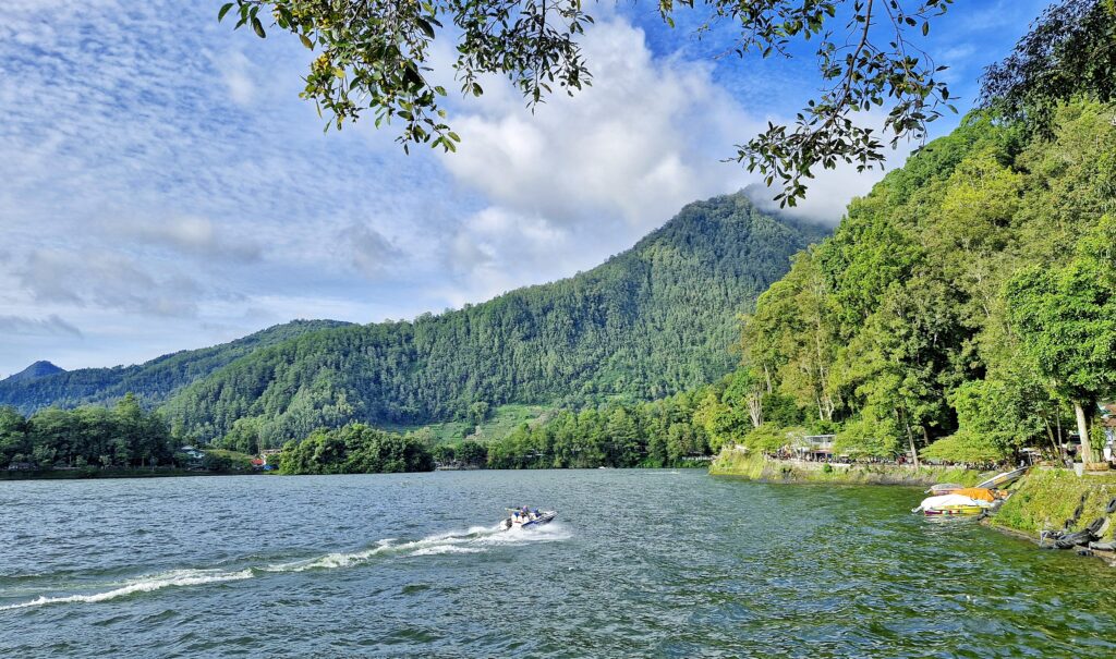 Visitors enjoying a boat ride on Telaga Sarangan lake in East Java
